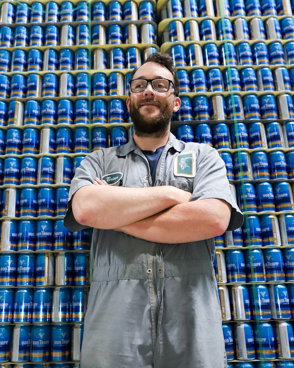 employee standing in front of cans of beer