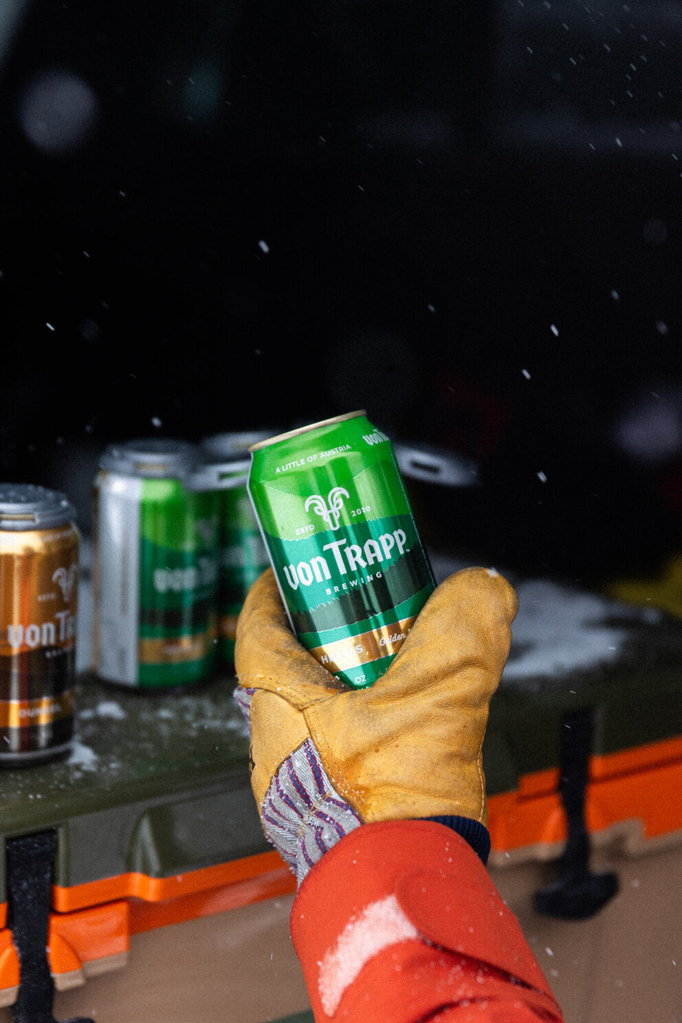 person wearing gloves and holding can of helles