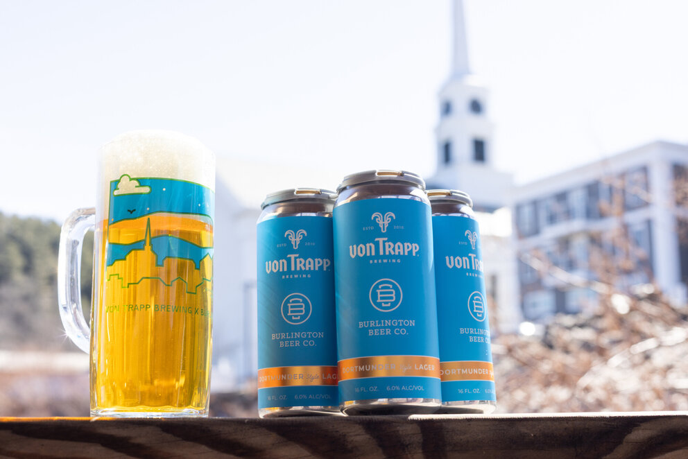 a group of cans and a glass of beer