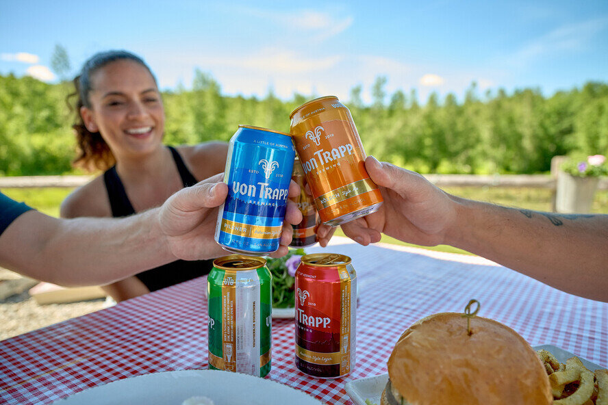 a group of people clinking cans at a picnic table