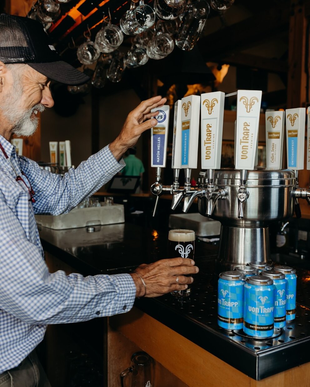 a man standing at a bar with a glass of beer