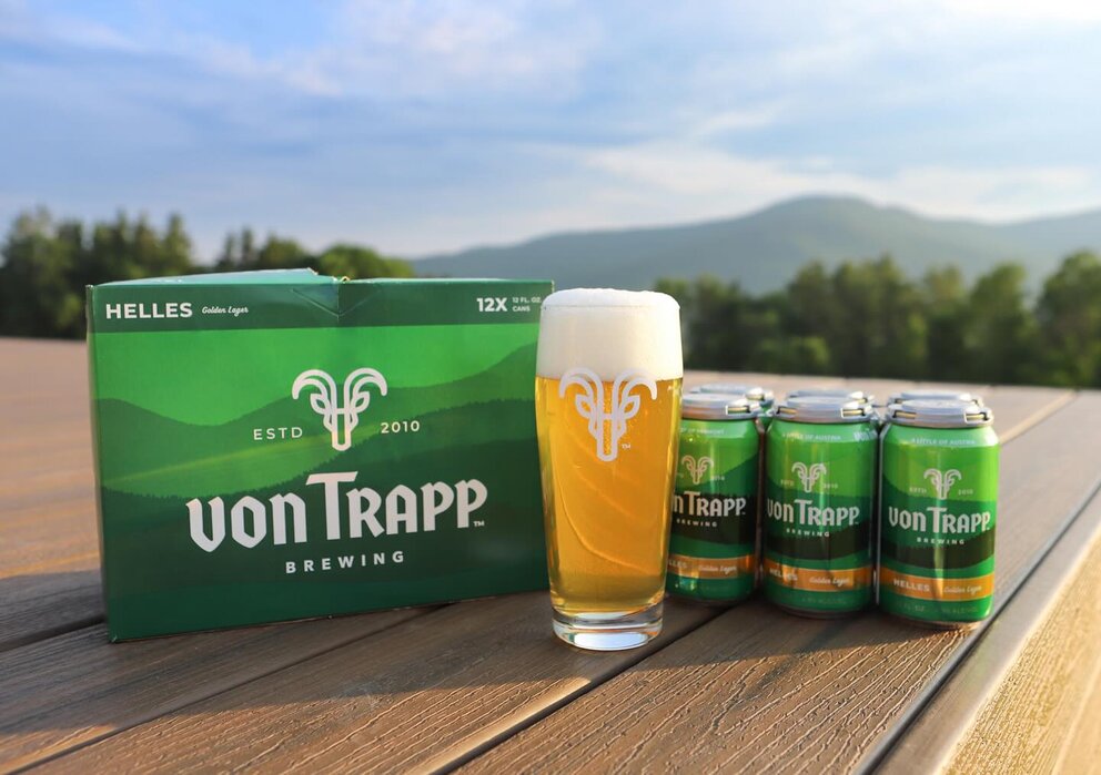 a group of cans and a glass of beer on a table