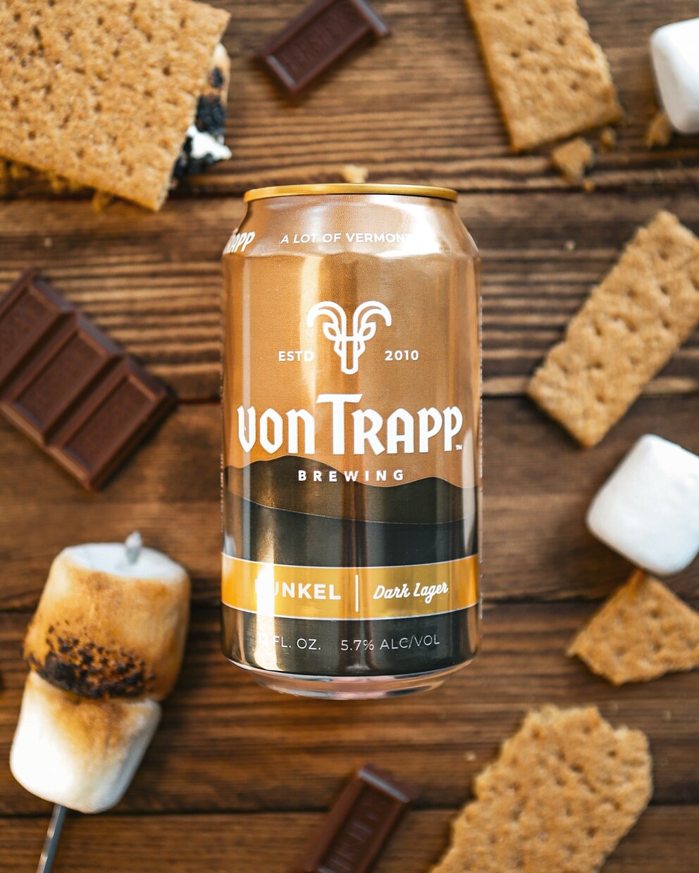 a can of beer next to marshmallows and chocolate