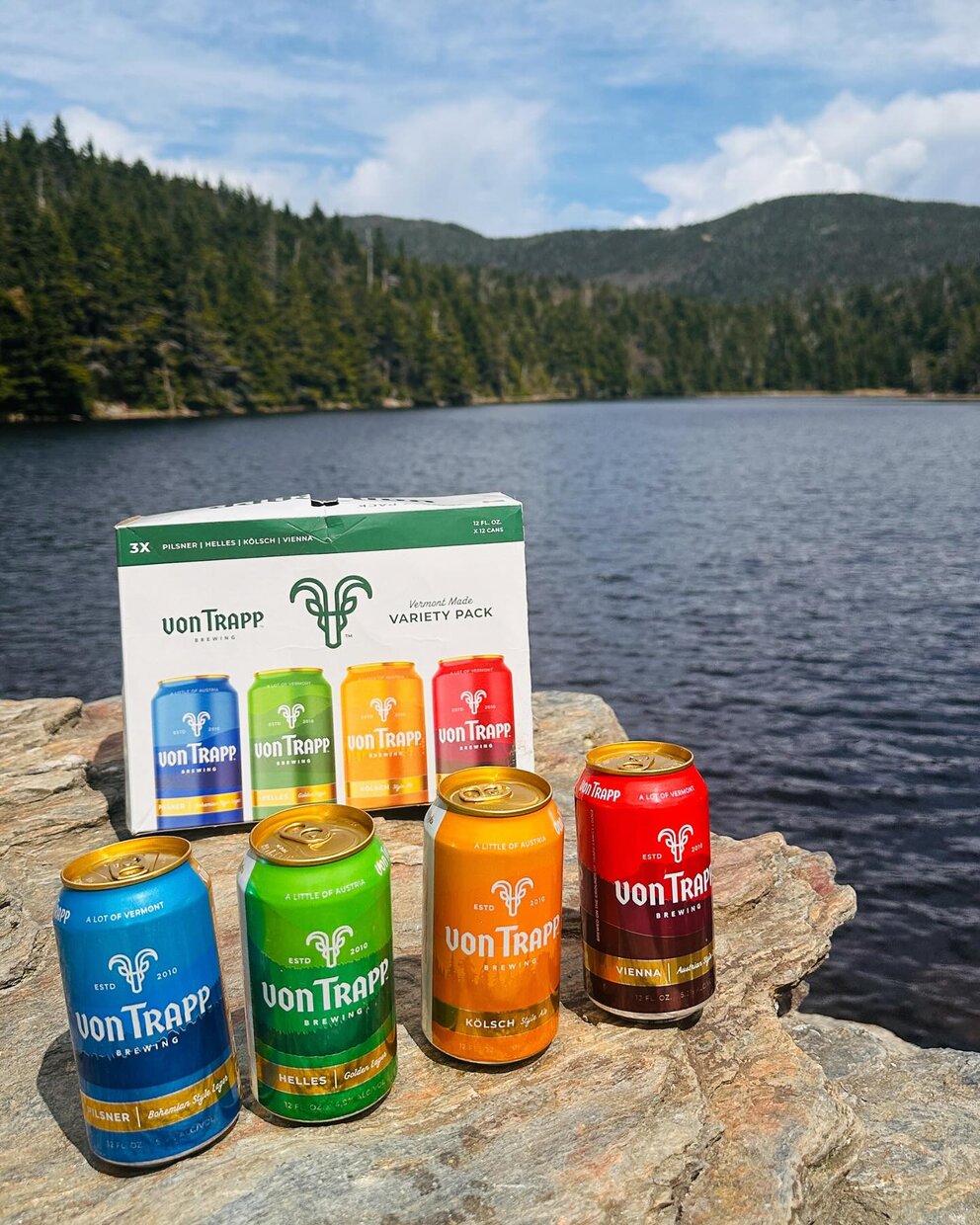 cans of beer on a rock by a lake