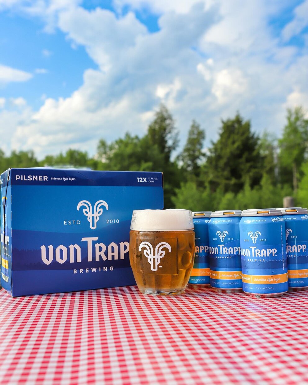 a group of cans and a glass of beer on a table