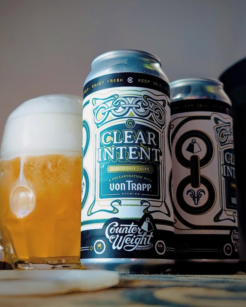 a group of cans and a glass of beer