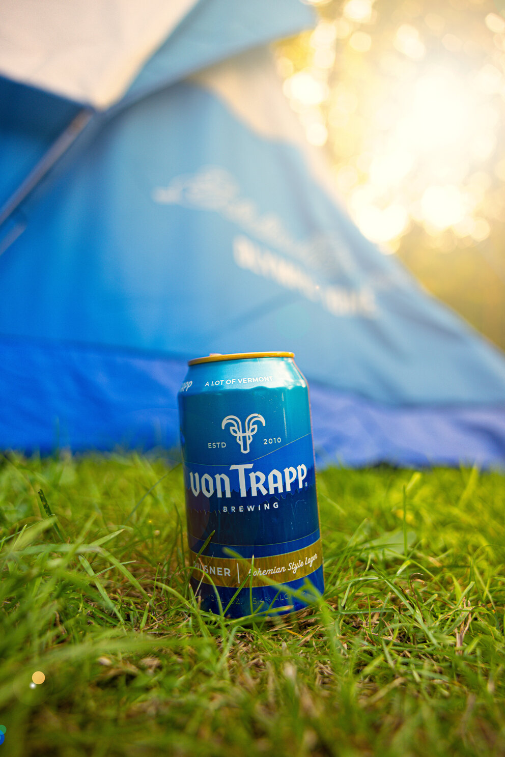 a blue can on grass in front of a tent
